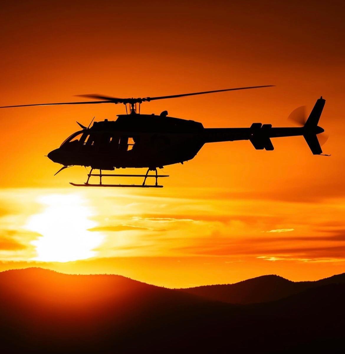 Helicóptero em voo durante o pôr do sol